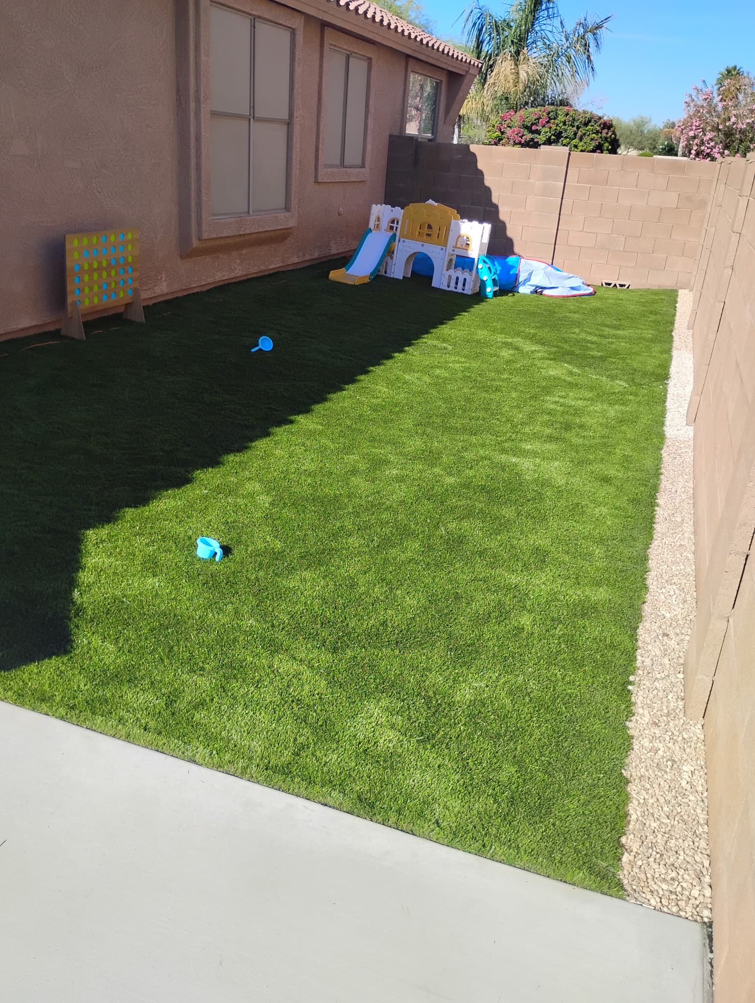 Side yard after artificial turf installation with children play area
